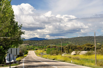 Empty road along landscape and against sky