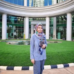 Portrait of woman standing against building