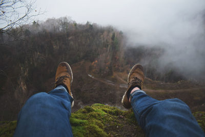 Low section of man on landscape against sky