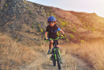 Portrait of boy riding motorcycle on field