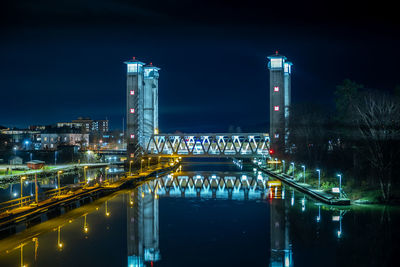 Railway bridge reflecting on the water surface in the canal in the evening