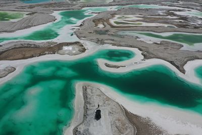 Aerial view of person standing on land looking at water on field