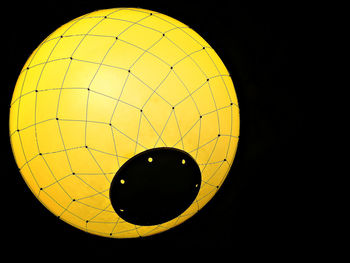 Low angle view of illuminated lamp against black background
