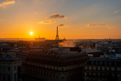 Aerial view of buildings in city during sunset