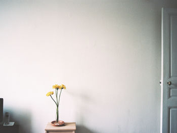 Close-up of yellow flower vase on table at home