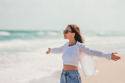 Portrait of young woman standing at beach