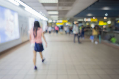 Woman walking in illuminated underground walkway