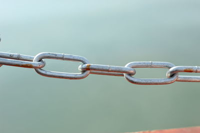 Close-up of chain against blue sky