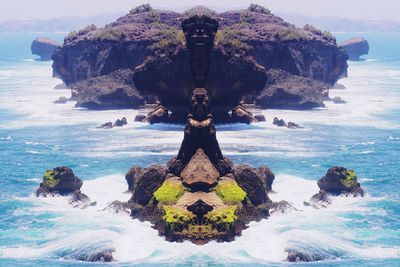 Digital composite of rock formation in sea against sky