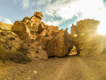 Low angle view of rock formations against cloudy sky
