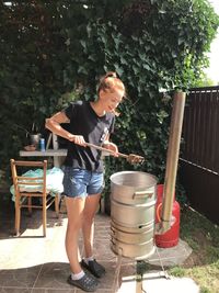 Full length of boy standing against wall in yard