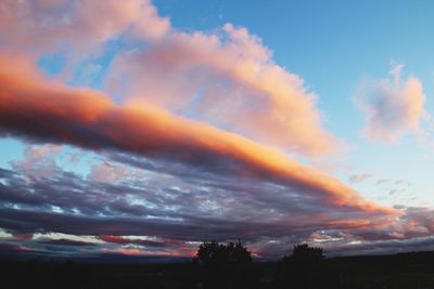 Low angle view of rainbow against sky at sunset