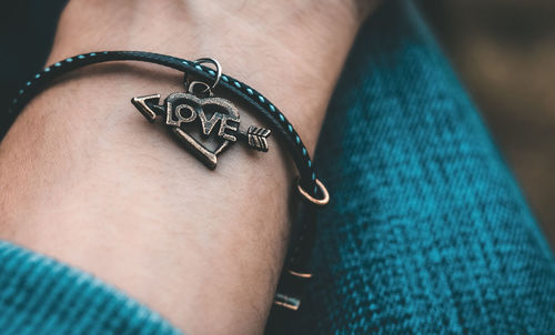 Close-up of person wearing bracelet with love text