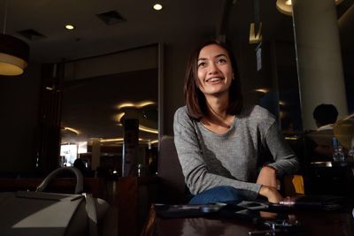 Portrait of young woman sitting in restaurant