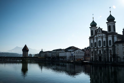 Reflection of building in water against clear blue sky