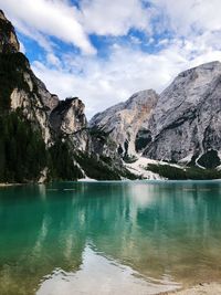 Scenic view of lake by mountains against sky