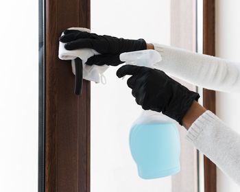 Cropped hand of person cleaning window