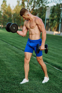 Full length of shirtless man standing outdoors