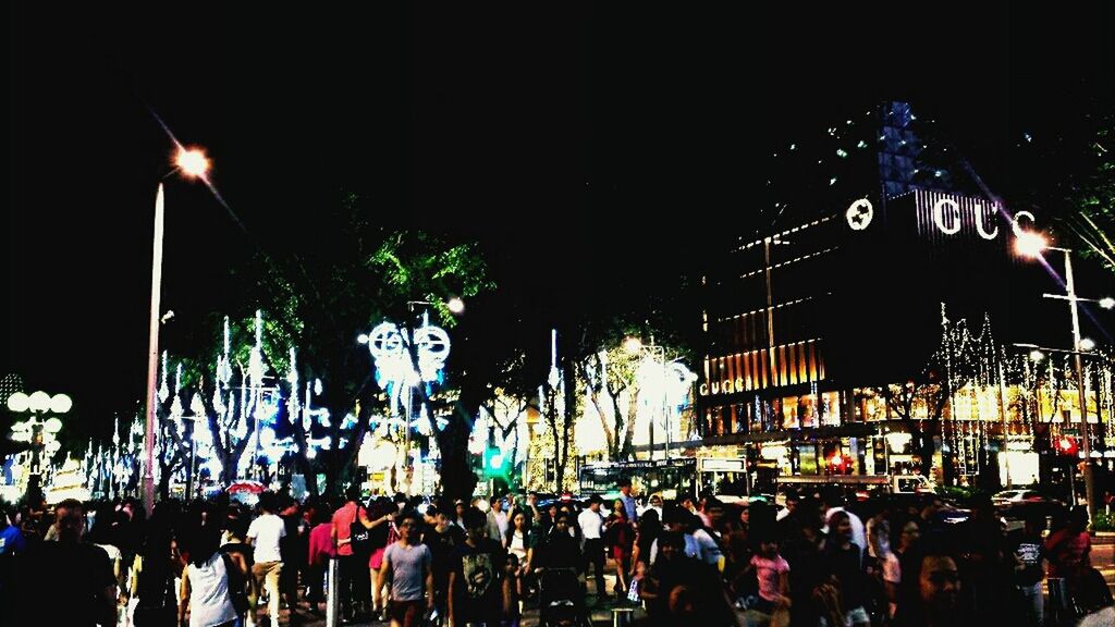 illuminated, night, large group of people, men, lifestyles, person, crowd, leisure activity, street, text, city life, city, communication, lighting equipment, street light, clear sky, outdoors, arts culture and entertainment, sky