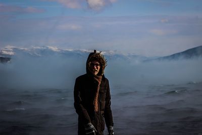 Woman standing on mountain against sky