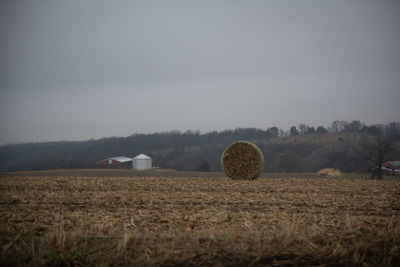 Hay bales on field against sky