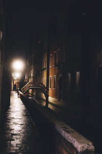 View of illuminated street amidst buildings at night