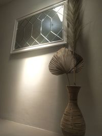 Low angle view of illuminated lamp against wall at home