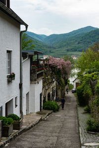 Footpath amidst buildings against sky