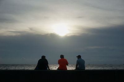 Silhouette of people sitting on beach