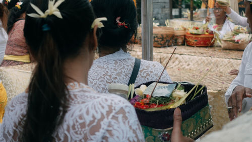 Rear view of women sitting on table by potted plant