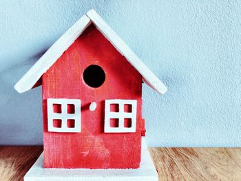 Close-up of red birdhouse on wall of building