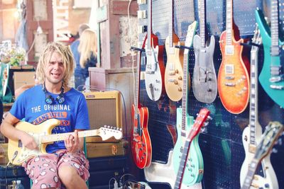 Full length of a smiling young woman playing guitar