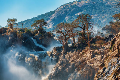 Scenic view of waterfall against sky