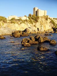 Rocks by sea against sky