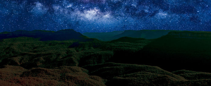 Scenic view of mountains against sky at night