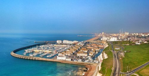 High angle view of city by sea against clear sky