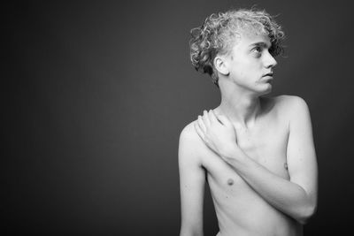 Portrait of woman looking away against black background