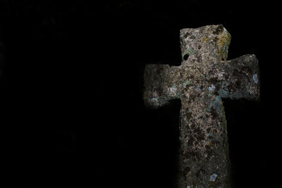 Close-up of cross against black background