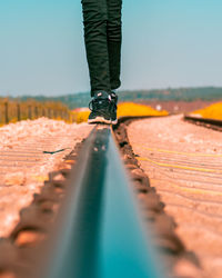 Low section of person balancing on railroad track