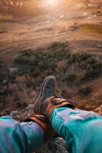 Low section of man relaxing on rock