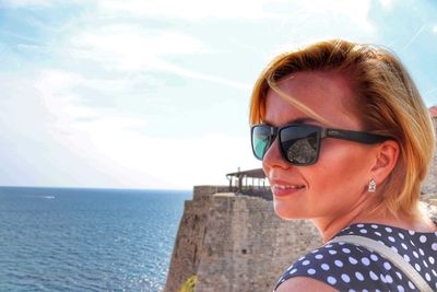 Portrait of smiling young woman against sea