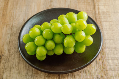 High angle view of grapes in bowl on table