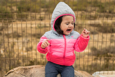 Boy in pink while standing outdoors