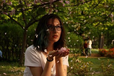 Teenage girl holding flowers in park