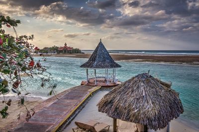 Pier on sea against cloudy sky