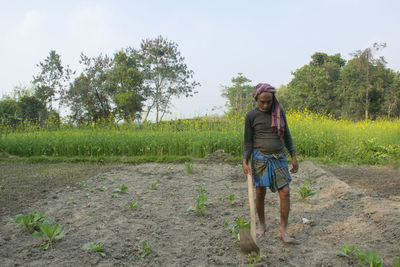 Full length of woman standing on field against sky