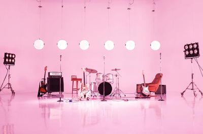 Illuminated lighting equipment on table against wall