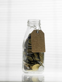 Coins in bottle on white table