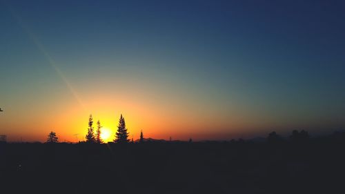 Silhouette landscape against clear sky during sunset