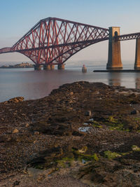 Bridge over calm lake against clear sky